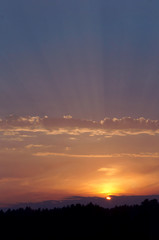 Sunset over a pond. Reflection of sunlight in the water. Red sky in the sunset light.