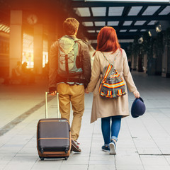 Fototapeta premium Rear view of amorous hipster couple walking down station and chatting outdoors. Holyday and weekend concept