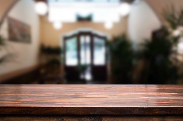 Selected focus empty brown wooden table and Coffee shop or restaurant blur background with bokeh image. for your photomontage or product display.