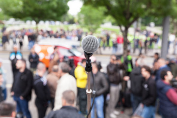 Political protest. Demonstration. Microphone in focus against blurred crowd.