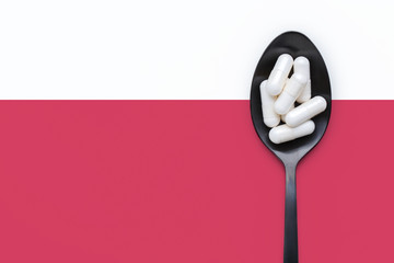 Supplement capsules on black spoon