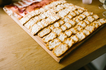 Crackers with ham. Snacks on the tray. Soft focus