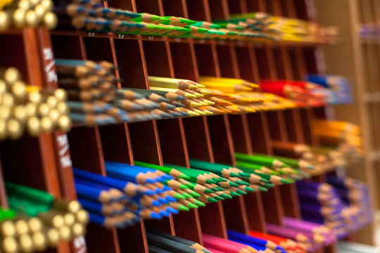 Colored pencils lie on the shelves in the store. Small depth of field.