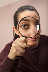 Fototapeta na wymiar Woman looking through magnifying glass