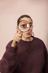 Woman looking through magnifying glass