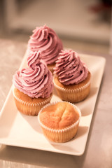 close up view of sweet cupcakes on plate on counter in restaurant kitchen