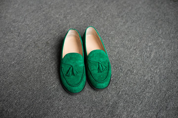 Green man’s shoes on a grey floor