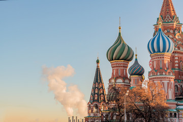 Obraz premium St Basils cathedral on Red Square in Moscow and smoking pipes of power plant on sunset