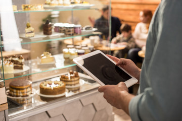 partial view of barista using tablet at work in cafe