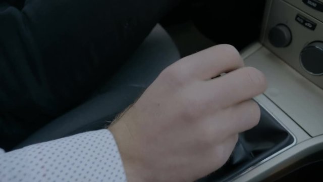 Hand of man changing gears in car 
