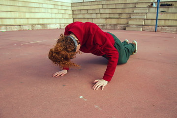 Mujer joven haciendo flexiones en la calle 