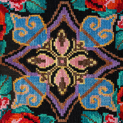 Embroidery hand made cross-stitch pattern in ethnic style on a black background fashion trend 2018