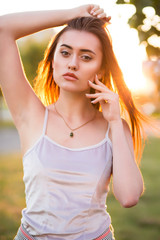 Naklejka premium Glamor brunette woman with perfect skin posing in rays of sun at sunset