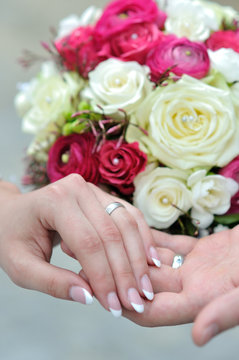 the hands of young married couples and the wedding bouquet