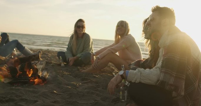 Group of friends having fun on beach during autumn day. Shot on RED Hellium 8K