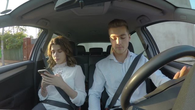 Driver and girlfriend use smart phones and texting while driving and not paying attention to road 
