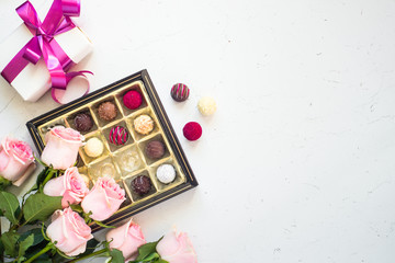 Pink rose present and truffle on white background. Top view copy space.