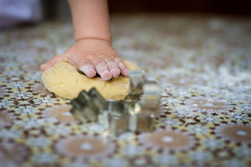 Hands baking dough with rolling pin on table. little chef  bake in kitchen.