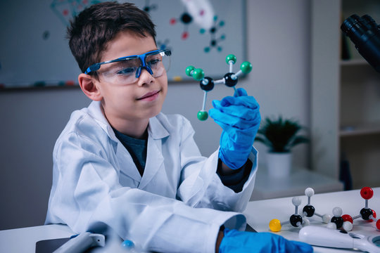 Science education. Cute boy holding molecular model - Powered by Adobe