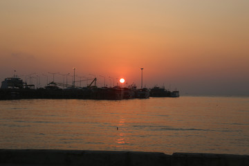 Fototapeta premium Sunset Ferry Pier Many boats are parked. And the sun is red.