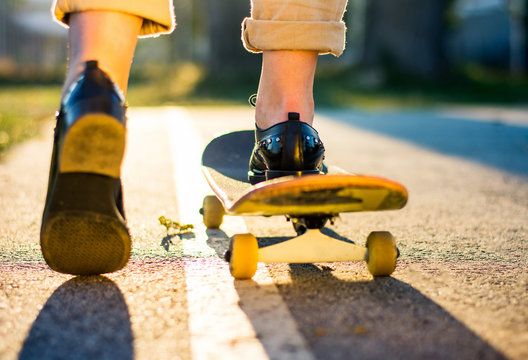 Female riding a skateboard at sunset