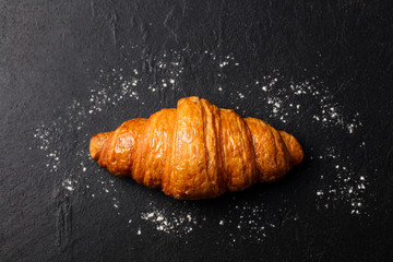 Fresh croissant on a slate background. Top view