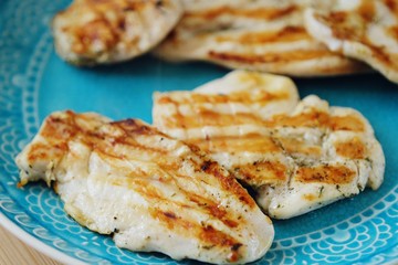 Fresh chicken fillet grilled in a blue plate 