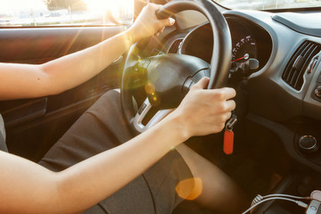 Female hands hold the steering wheel, close-up. A woman is driving a car.