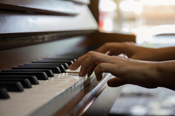 Obraz premium Close up of happy woman's hand playing the piano in the morning.