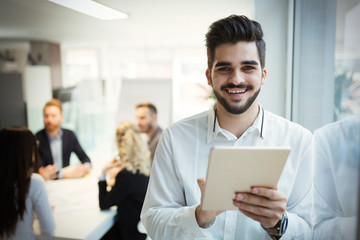 Handsome businessman using tablet pc in office