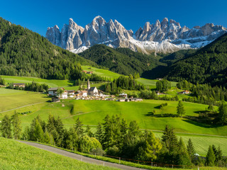 Fototapeta na wymiar Val di Funes valley, Santa Maddalena touristic village, Dolomites, Italy, Europe. September, 2017. Green grass and blue sky.