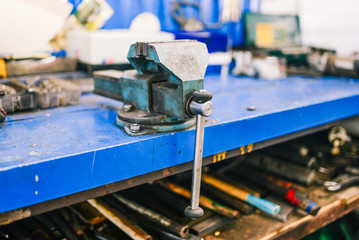 Vise blue in the workshop. Joiner tools for fixing parts for various types of processing. Metal clamps.