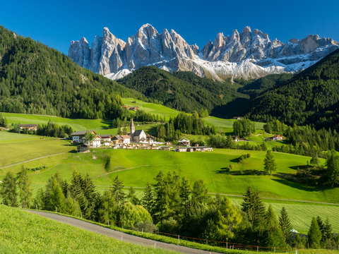 Val di Funes valley, Santa Maddalena touristic village, Dolomites, Italy, Europe. September, 2017. Green grass and blue sky.