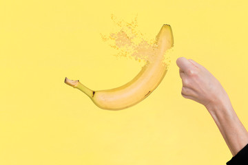 mano femminile colpisce e frantuma una banana