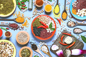 Assortment of legumes bowls and various spices  top view - Healthy food background flat lay of colorful kitchen table with beans and seeds from around the world - Concept of alternative protein diet