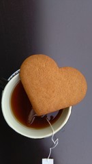 cup of tea and heart shaped cookie top view.. space for text