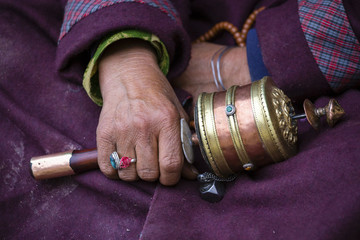 Old hands of a Tibetan woman holding prayer buddhist wheel at a Hemis monastery, Leh district, Ladakh, Jammu and Kashmir, north India