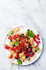 Fresh berries on white plate. Copy space. Top view