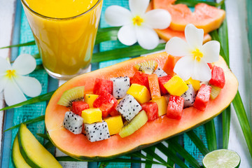 Fruit salad in half of papaya with mango smoothie