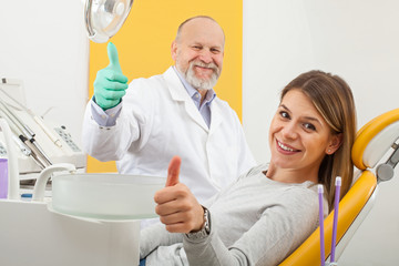 Stomatologist and female patient showing thumbs up