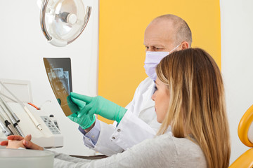 Dentist and patient looking to dental x-ray