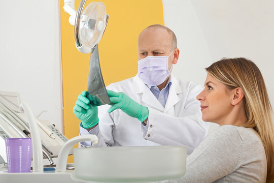 Dentist and patient looking to dental x-ray