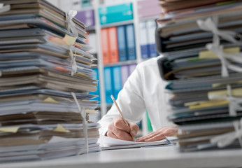 Businessman working in the office and piles of paperwork - obrazy, fototapety, plakaty