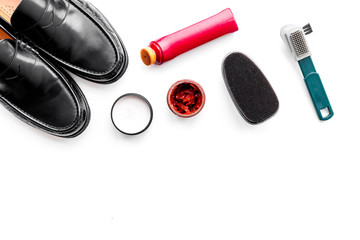 Shoe care products. Leather men shoes, shoe polish, brushes, wax on white background top view copy space
