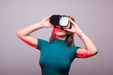 Sexy woman wearing VR virtual reality head set on gray background