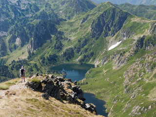 Fototapeta na wymiar Hiker overlooking a lake, french pyrenees