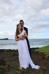 Fototapeta na wymiar hugging bride and groom at by sea side in hawaii