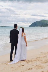 bride and groom walking on the beach