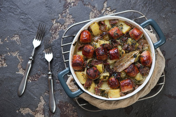 Bowl of Dublin coddle or one of traditional Irish meals on a metal cooling rack, view from above on a brown stone background