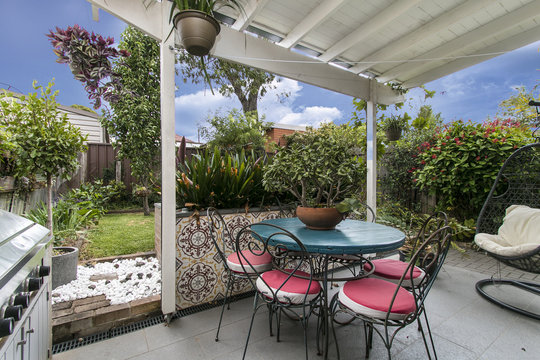 Back Yard With Outdoor Seating And Barbecue With Family. Beautiful House